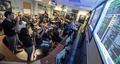 New Horizons Flight Controllers celebrate after they received confirmation from the spacecraft that it had successfully completed the flyby of Pluto, Tuesday, July 14, 2015, in the Mission Operations Center (MOC) of the Johns Hopkins University Applied Physics Laboratory (APL), Laurel, Maryland. Credits: NASA/Bill Ingalls. 071415plutonewhorizonsteam