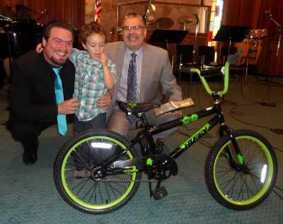 Logan Allen with his new bike, his dad Kris Allen, and Lakeport Christian Center Pastor Mike Suski on Easter Sunday, March 31, 2013, in Lakeport, Calif. Courtesy photo. 033113lccboysbike