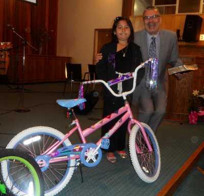 Lakeport Christian Center Pastor Mike Suski awards a new bike to Gloria Marquez on Easter Sunday, March 31, 2013, in Lakeport, Calif. Courtesy photo. 033113lccgirlsbike
