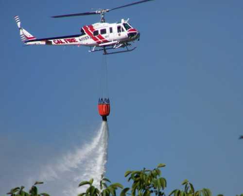 A Cal Fire helicopter drops water on the Denton Fire in Clearlake, Calif., on Saturday, July 13, 2013. Photo by Elizabeth Hoskins. 071313dentonhoskins1
