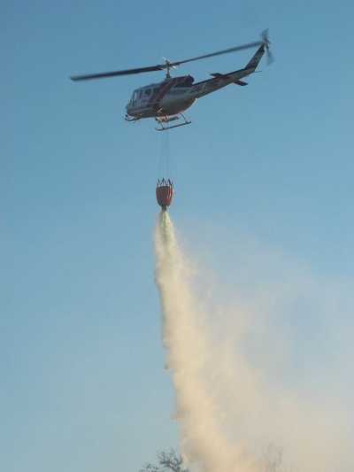 A Cal Fire helicopter drops water on a small wildland fire in Spring Valley east of Clearlake Oaks, Calif., on Saturday, July 27, 2013. Photo by Linda Stapleton. 072713springfirecopterjs