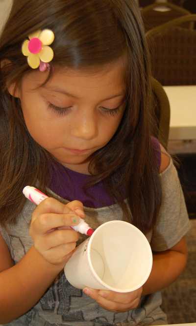 Briana Espinoza colors her plant pot during craft day at the new Middletown Library in Middletown, Calif., as part of the 2013 Children's Summer Reading Program. Photo by John Lindblom. mtownlibrarypotcoloring