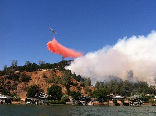 A Cal Fire air tanker drops retardant on a fire at Patterson and Lakeshore drives in Clearlake Park, Calif., on Wednesday, June 5, 2013. Photo by Sheri Salituri-Young. 060513calfiretanker