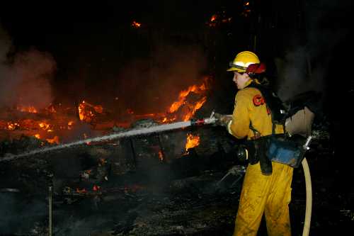 A Cal Fire firefighter works on a house fire in Spring Valley near Clearlake Oaks, Calif., early on the morning of Monday, June 10, 2013. Photo by Kenneth R. Wells. 061013springvalleyfire1