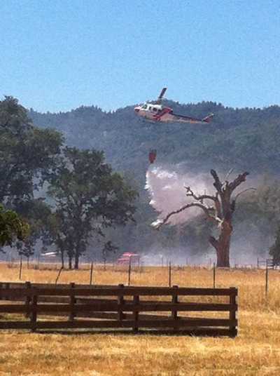 A Cal Fire helicopter drops water on a five acre wildland fire on Dry Creek Road Cutoff near Middletown, Calif., on Wednesday, June 12, 2013. Photo by LaTrease Walker. 061213drycreekfire