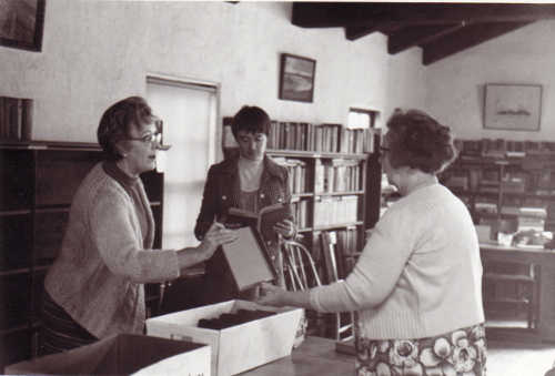 Middletown Gibson Library, fall 1971. Carolyn Dorn, center, of the Lake County Library Project and two unidentified women sort and organize books in the Middletown Library, preparing it to operate under the Library Project. The Library Project incorporated four independent libraries around Lake County and paved the way for the Lake County Library system. Photo from the files of the Lake County Library Project. 1971gibsonlibraryorganizing