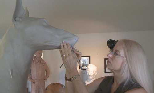 Sculptor Paula Slater of Hidden Valley Lake, Calif., working on one of the sculpture for a national monument to honor dogs that have served in wars from Word War II to the present. Courtesy of Paula Slater. slatersculpting