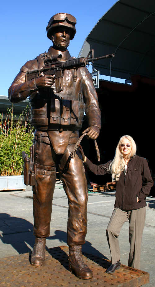Sculptor Paula Slater of Hidden Valley Lake, Calif., with the statue of a soldier she created for a national monument to honor dogs that have served in wars from Word War II to the present. Courtesy of Paula Slater. slatersoldierbronze