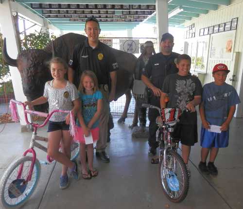 From left to right, bike and yogurt winners at a special event at Tatonka Land Mini Golf in Clearlake, Calif., on Saturday, September 14, 2013, were Jadyn Copas, 9, Ellenie Graves, 7, Officer Michael Carpenter, Officer Elvis Cook, Donte Price, 11, and Uzziel Alvarez, 8. 091413tatonkabikes