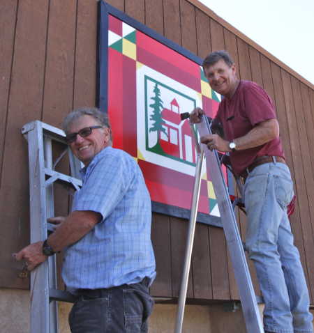 Jim Herrmann and Gary Maes install the new “Poppy’s School” on the Kelseyville Student Services building located at 4325 Main St. in Kelseyville, Calif. Photo courtesy of the Lake County Quilt Trail. lcqtpoppysschool