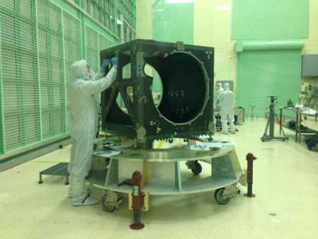 An engineer checks ICESat-2's box structure, shortly after its arrival in a NASA clean room in May. Over the next two years, engineers and technicians will attach electronics, optics, lasers, a telescope and more to the box, testing its function at each step. Credit: NASA's Goddard Space Flight Center/Kate Ramsayer. nasalaserbox
