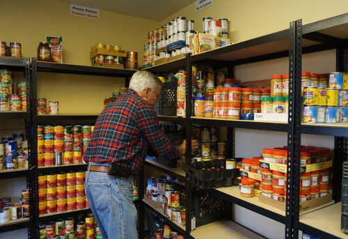Kelseyville Food Pantry volunteer Jim Horne checks the supplies in the storage building at Kelseyville Presbyterian Church during the twice-monthly food giveaway on Tuesday, January 26, 2016, in Kelseyville, Calif. Photo by Elizabeth Larson/Lake County News. 012616kfphorne