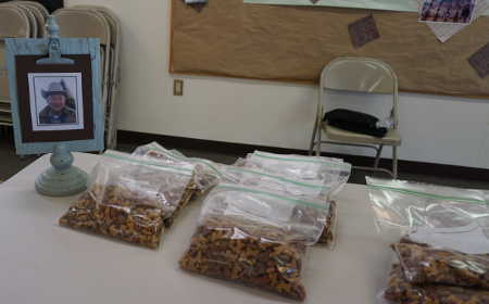 A picture of the late Walt Lyon graces the dog food table at the Kelseyville Food Pantry giveaway on Tuesday, January 26, 2016, in Kelseyville, Calif. Lyon advocated for making dog food available at the twice-monthly giveaways, and on that day it was one of the first items whose supply was exhausted. Photo by Elizabeth Larson/Lake County News. 012616kfplyon