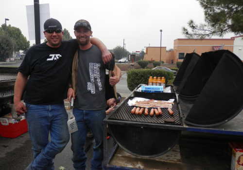 Members of the Coalition Crawlers and Low Budget Off Road Sage Scherman (left) and Beau Reinegger keep the barbecue fired up on Monday, September 14, 2015, in Clearlake, Calif., feeding evacuees displaced by the Valley Fire in the parking lot at Clearlake Walmart. The club was loaded with supplies when they arrived from the Monterey area to assist with the relief effort. Photo by Denise Rockenstein/Lake County News. 091415valleyevacsbbq