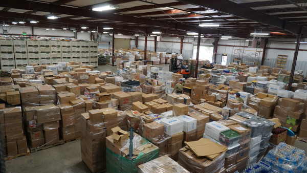 The 66,000-square-foot Work Right building in Lakeport, Calif., shown here on Sunday, October 18, 2015, is nearly full of donations that have come in from around the United States to help Valley fire survivors. “Mount St. Moose,” seen at the back of the photograph, is composed of 626 pear bins of items brought from the Clearlake Oaks Moose Lodge alone that remain to be sorted. Photo by Elizabeth Larson/Lake County News. 101815valleydonationsworkright