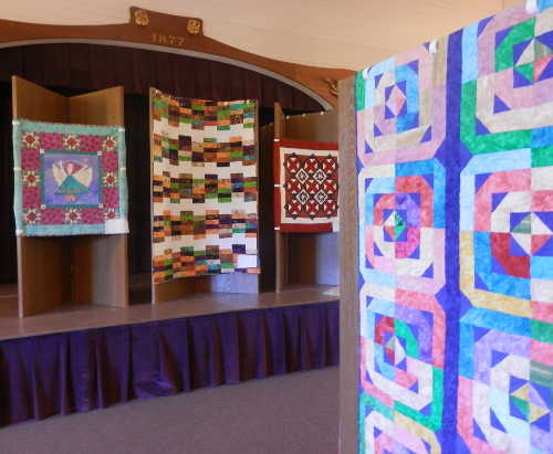 The annual Quilt and Fiber Art Exhibition opens Saturday, August 15, 2015, at the Lower Lake Historic Schoolhouse Museum in Lower Lake, Calif., with an artists' reception from noon to 2 p.m. in the Weaver Auditorium. The event will include refreshments and demonstrations by the artists. Shown above are quilt's in this year's display. Photo by Denise Rockenstein/Lake County News. aug2015drquiltexhibit1