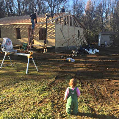 Little Emilia, daughter of homeowners Justin Lord and Courtney Van Leuven, watches the quick progress of her new home as it is being built in Middletown, Calif. The family lost its home in the 2015 Valley fire. Courtesy photo. lordfamilyhomerebuild