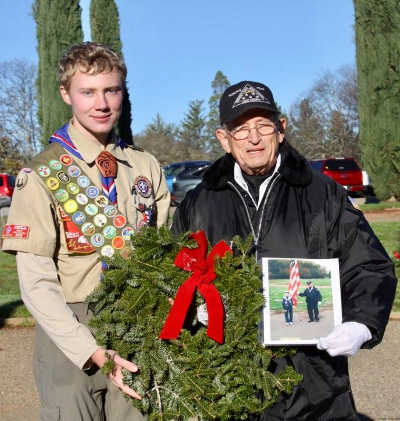 Boy Scout Brent Hinchcliff with veteran and Military Funeral Honors Team member Griff Ratterree at the Wreaths Across America ceremony at Hartley Cemetery in Lakeport, Calif., on Saturday, December 17, 2016. Ratterree holds his treasured photo of the two from a ceremony several years ago. Photo courtesy of Ginny Craven. 121716wreathsbrentandgriff